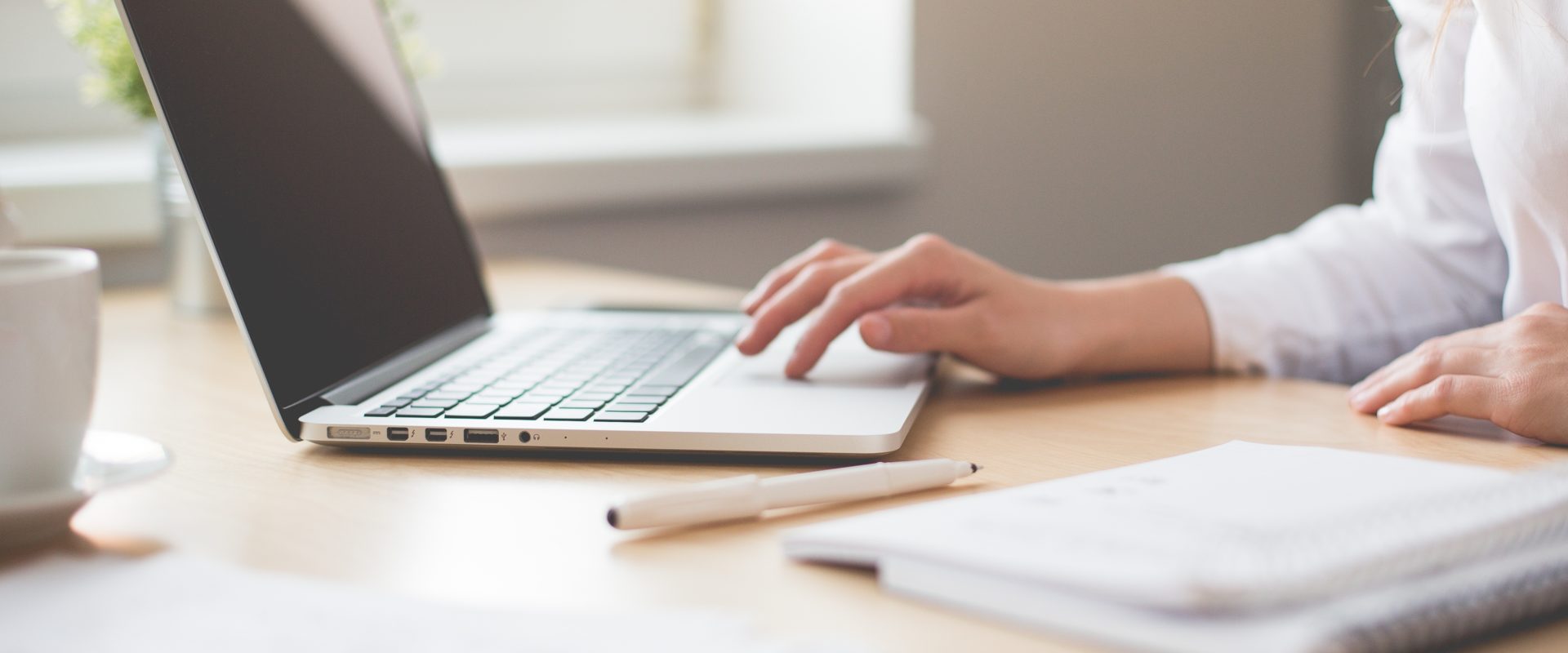 A women typing on a laptop.
