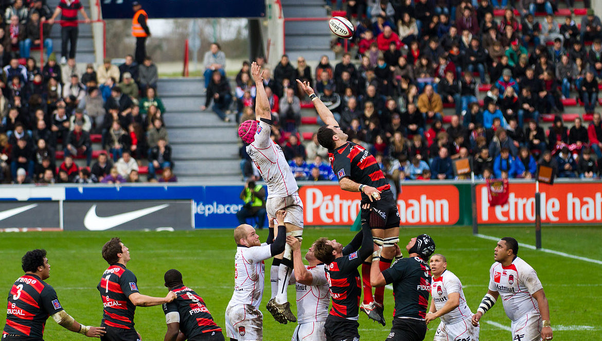 Two Rugby players jumping to catch the ball.